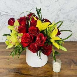 Red roses and yellow lilies arranged in a white vase