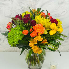 Mixed bouquet of roses, hydrangea, and alstroemeria in a glass vase