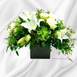 White lilies and roses in a black square vase