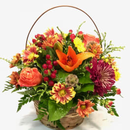 Basket arrangement with orange lilies, roses, and chrysanthemums