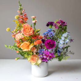 Colorful mixed flower arrangement in a white vase