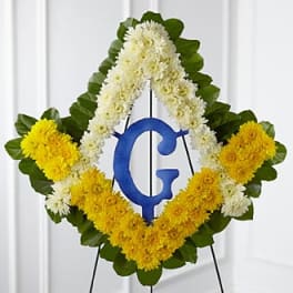Diamond-shaped floral wreath with yellow and white flowers on an easel