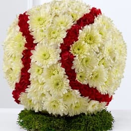Red and white chrysanthemum floral tribute on a green base