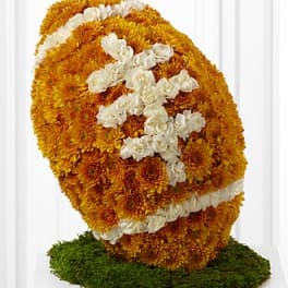 Orange and white floral football sculpture on a green base