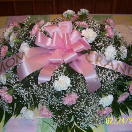 Large pink and white floral spray with a pink ribbon bow