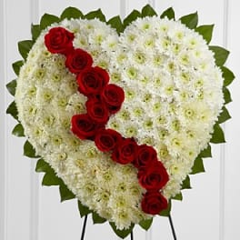Heart-shaped floral tribute with white chrysanthemums and red roses