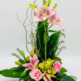 Pink lilies and roses arranged in a black rectangular vase