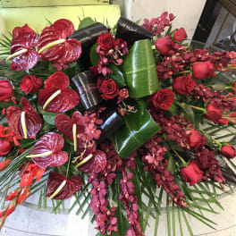 Large red floral arrangement with roses, orchids, and anthuriums