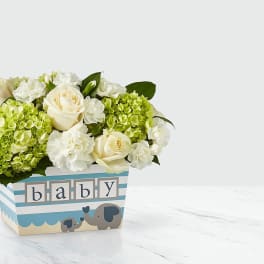 Cream roses and green hydrangeas in a baby-themed box