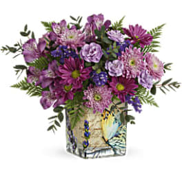 Purple mixed bouquet in a painted square vase