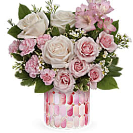 Pink and white roses in a patterned glass vase