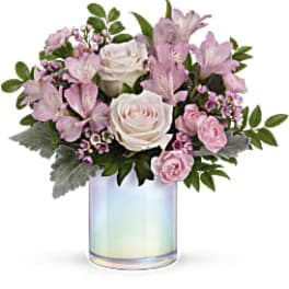 Pink and white flower arrangement in an iridescent glass vase