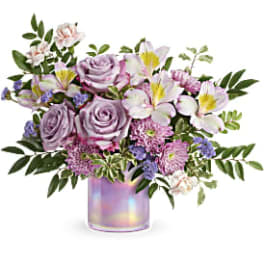 Lavender roses and lilies in an iridescent vase