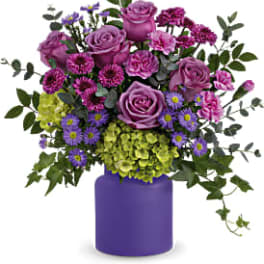 Purple and green mixed bouquet in a purple vase