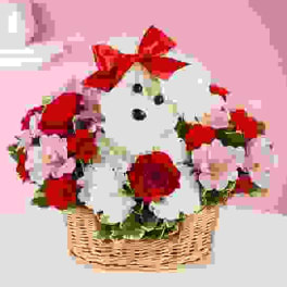 White teddy bear in a basket with red bows and pink flowers