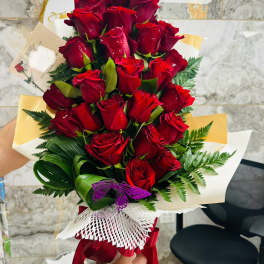 Bouquet of red roses wrapped with white and gold paper