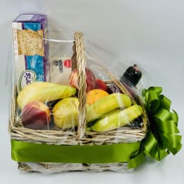 Gift basket with fruit, crackers, cheese, and a green ribbon