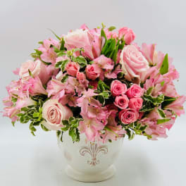 Pink roses and alstroemeria arranged in a white vase