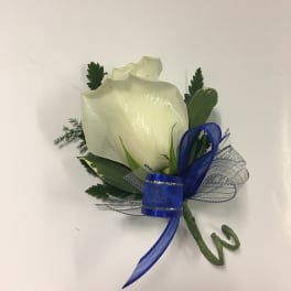 White rose boutonniere with blue ribbon and greenery