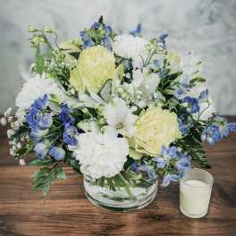 Bouquet of pale yellow and white flowers in a clear glass bowl vase