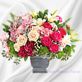 Mixed pink and white flower arrangement in a gray vase