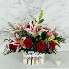 Bouquet of red roses and pink lilies in a decorative box