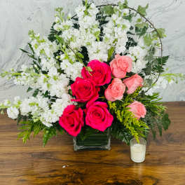 Pink and white rose arrangement in a square glass vase