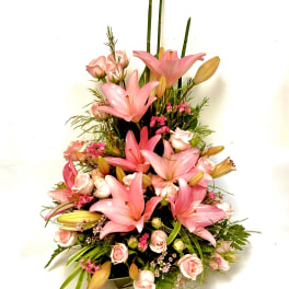Pink lilies and roses arranged in a tall bouquet