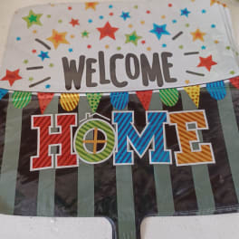 Colorful welcome home party banner with stars and pennants