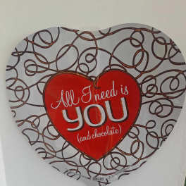 Heart-shaped balloon with the words "All I need is you (and chocolate)"