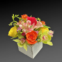 Mixed bouquet in a white wooden box with roses and orchids