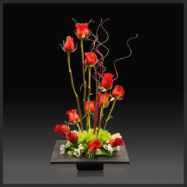 Tall arrangement of red roses on a low black pedestal