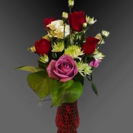 Red, pink, and white roses in a red vase