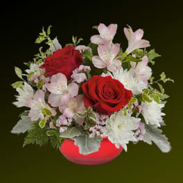 Red roses and pink alstroemeria in a red vase