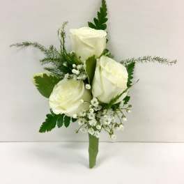 White rose boutonniere with small white filler flowers and greenery