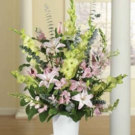 Tall pastel floral arrangement in a white pot