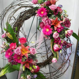 Two floral wreaths with pink and orange flowers on a wire frame