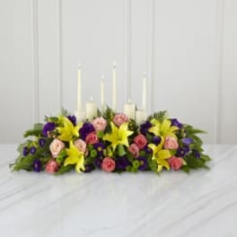 Low floral centerpiece with candles and yellow lilies