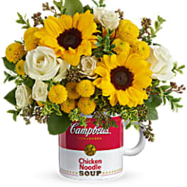 Sunflowers and white roses arranged in a Campbell's soup mug