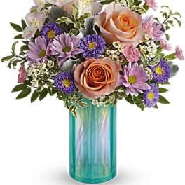 Bouquet of peach roses and purple daisies in a turquoise glass vase