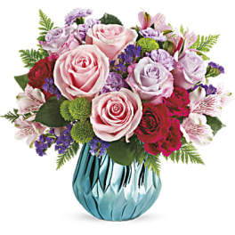 Pink and lavender rose bouquet in a blue glass vase