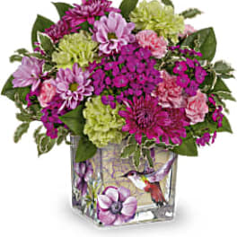 Mixed pink and green flower arrangement in a square glass vase