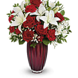 Red roses and white lilies arranged in a tall vase
