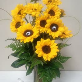 Sunflower bouquet in a glass vase with decorative googly eyes