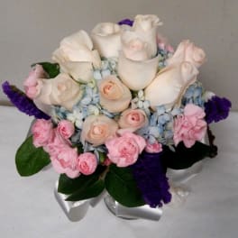 Bouquet of white roses, pink carnations, and blue hydrangeas with purple accents