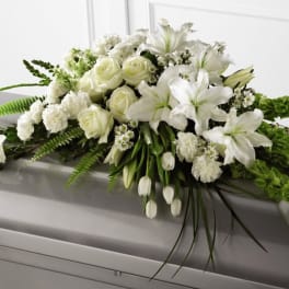 White floral casket spray with lilies and roses