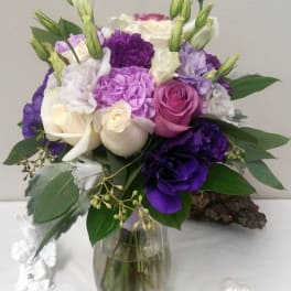 Bouquet of purple, pink, and white flowers in a glass vase