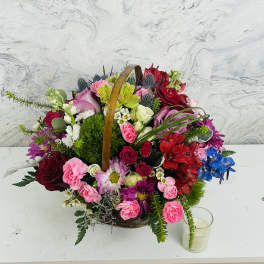 Basket arrangement of mixed pink, red, white, and blue flowers