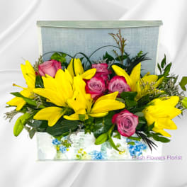 Yellow lilies and pink roses arranged in a rectangular box