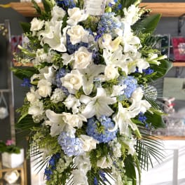 Large white and blue floral standing spray on an easel